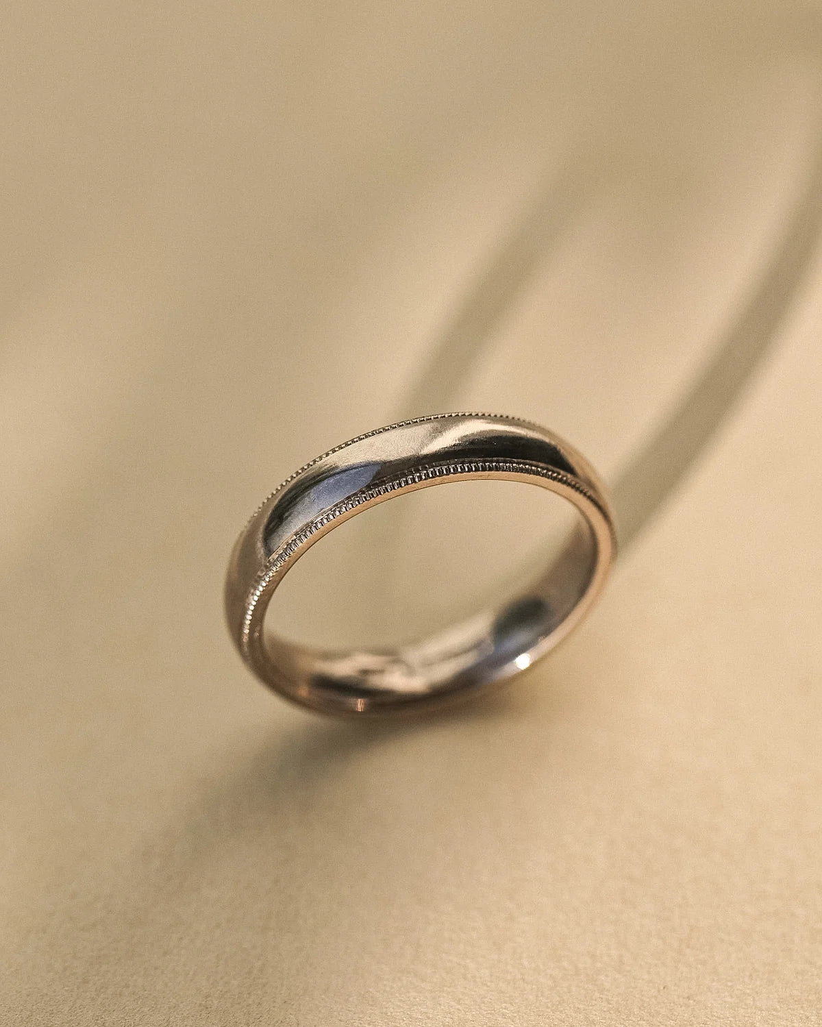 Angled view of handmade 18ct white gold court wedding ring