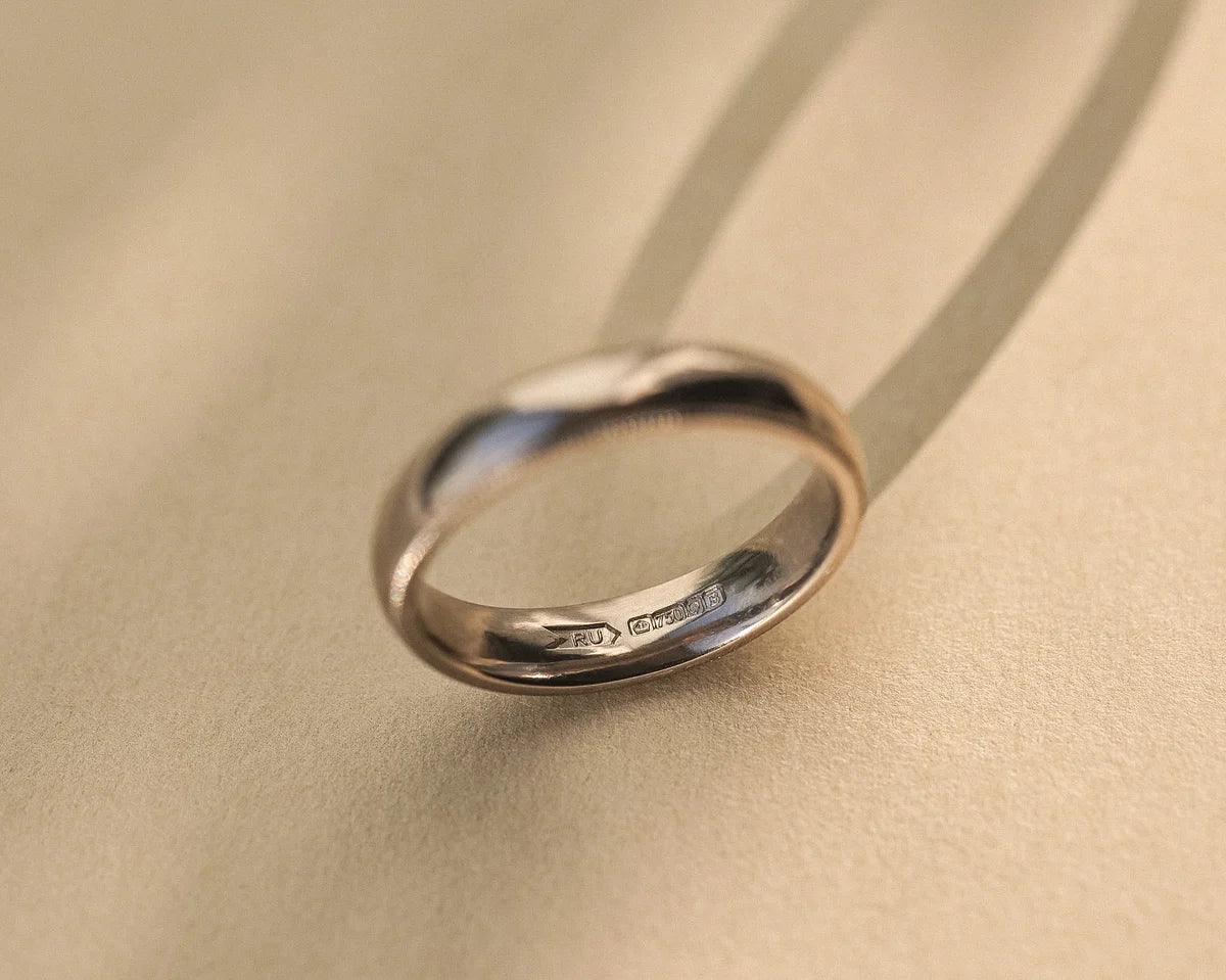 Side view of 4mm court wedding ring with hand engraved milled edge