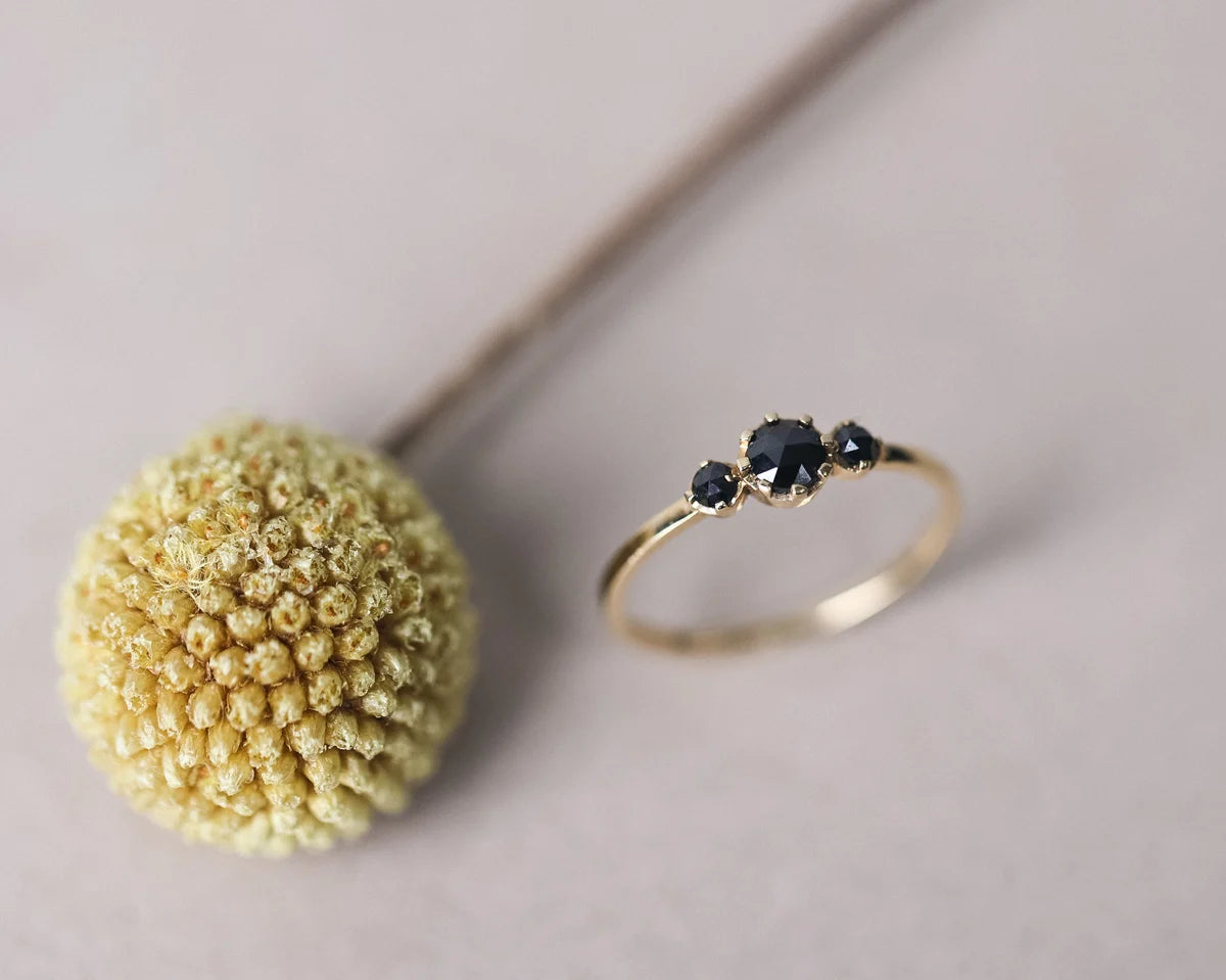 black rose cut diamond centre detail gold trilogy ring
