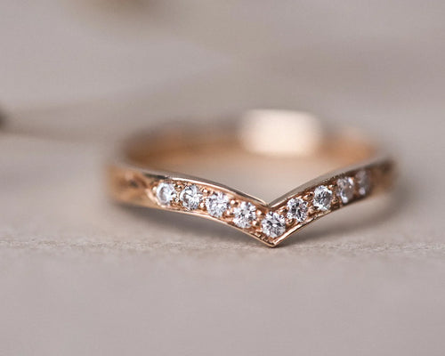close up brilliant cut diamonds on rose gold wishbone ring