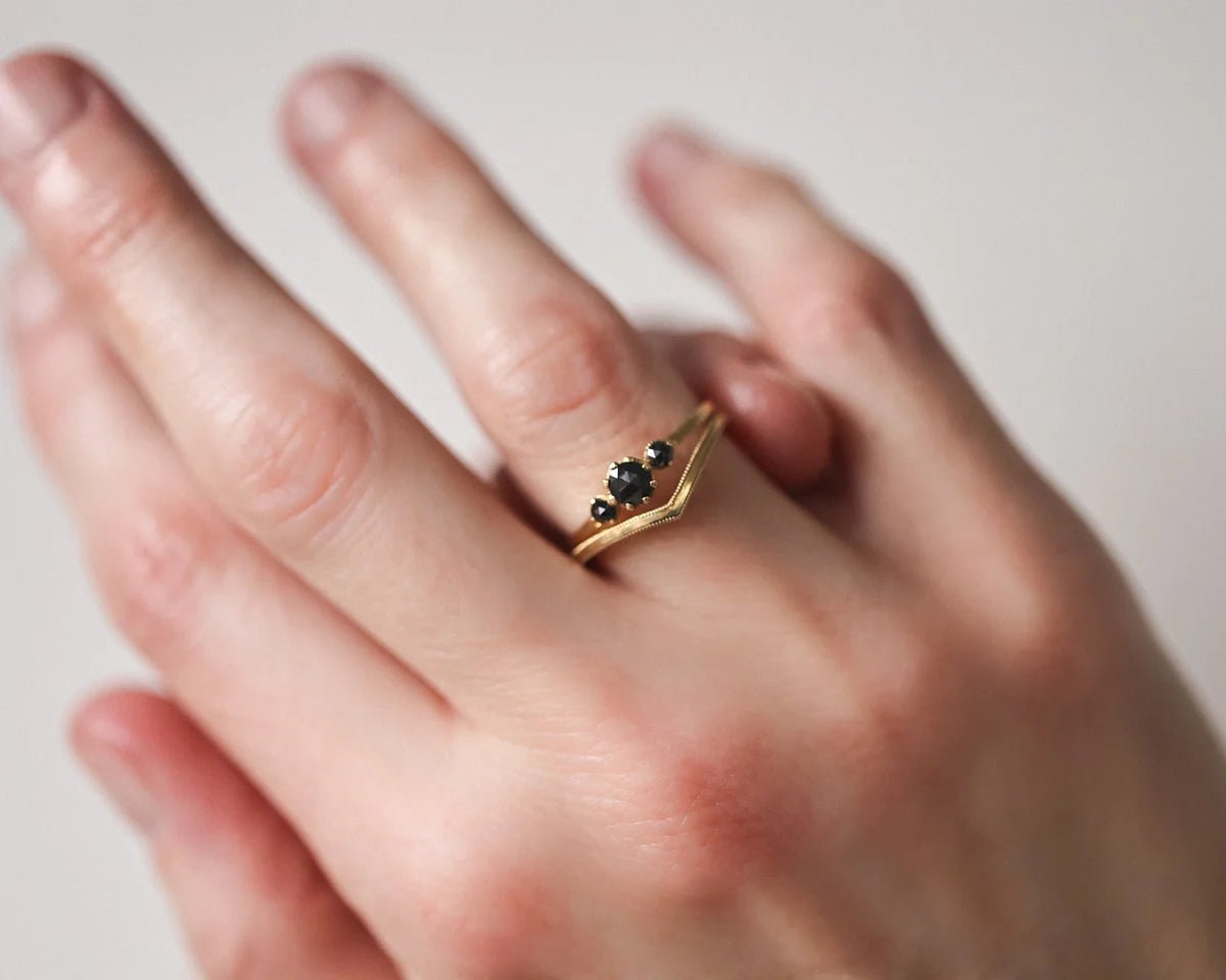 black diamond trilogy ring worn on hand gold band