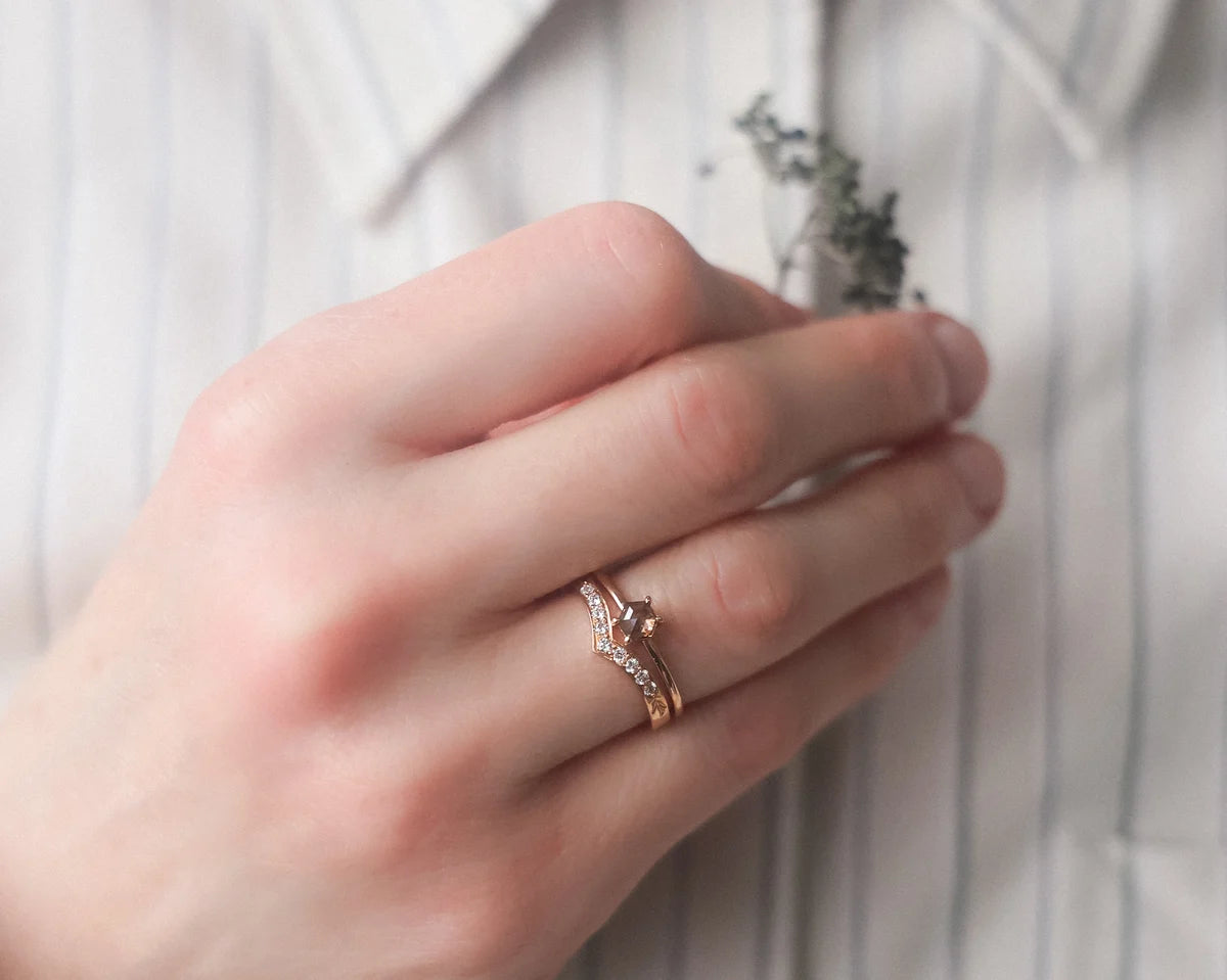 hexagonal diamond ring worn on hand rose gold band