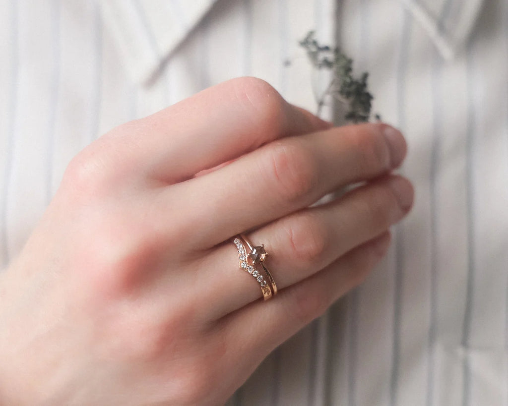 rose gold wishbone ring worn with engagement ring diamond band