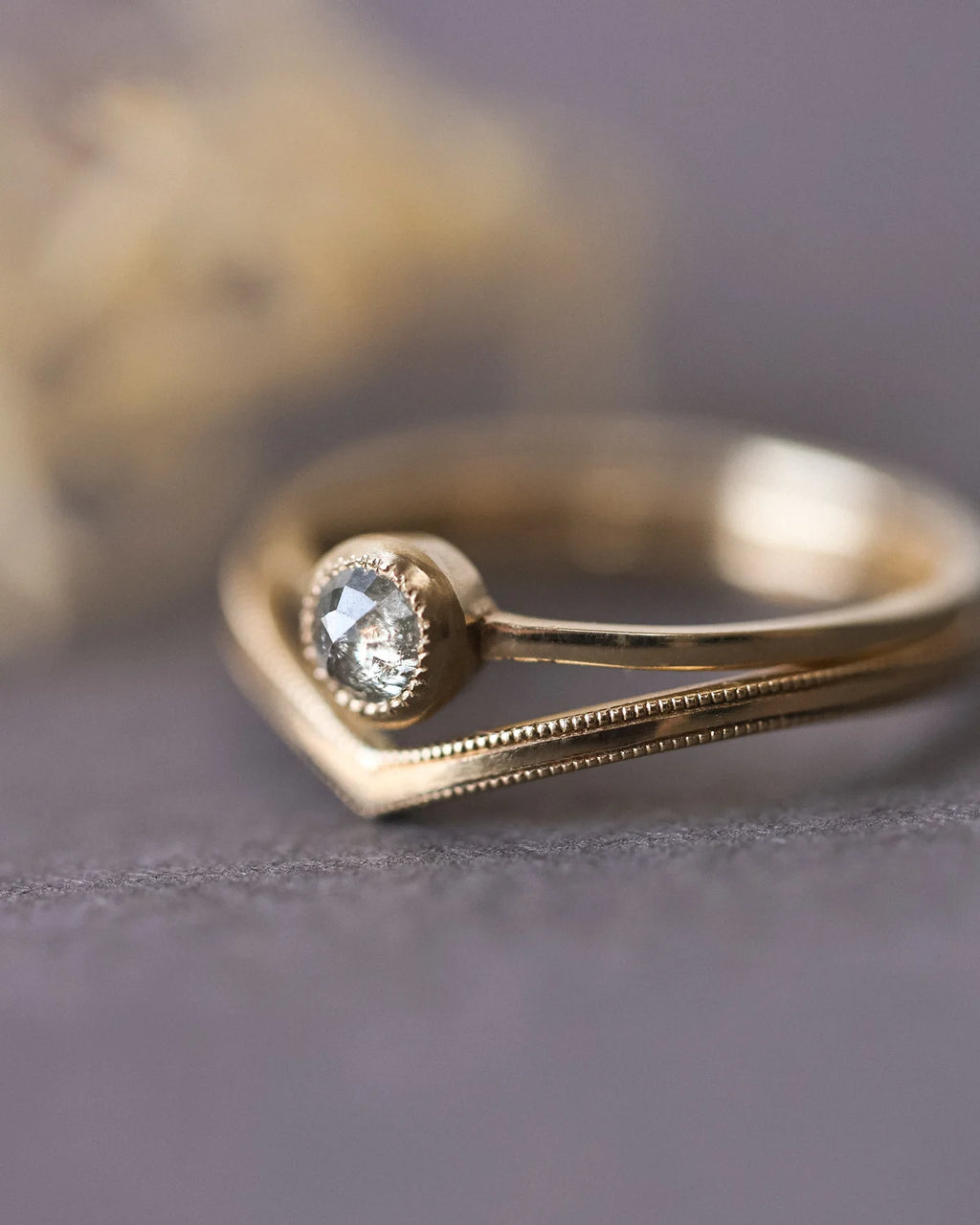 Close-up of rose-cut diamond ring stacked with wishbone band
