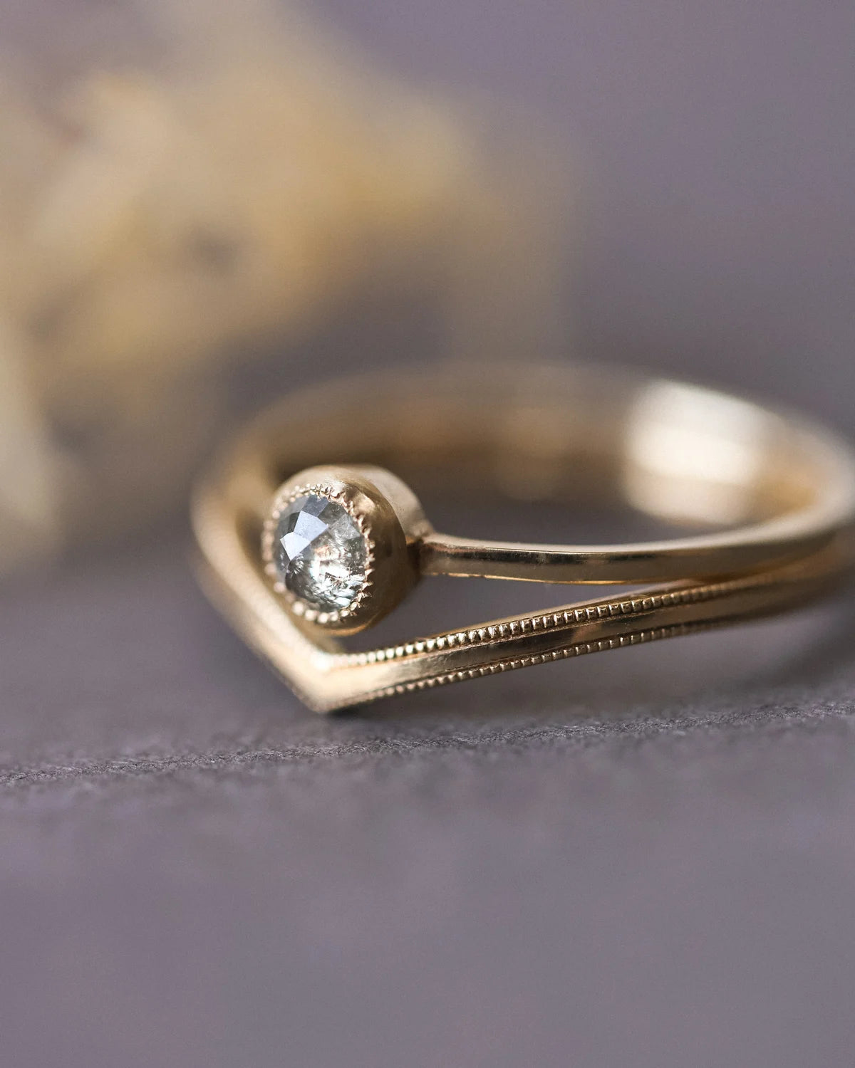 Close-up of rose-cut diamond ring stacked with wishbone band
