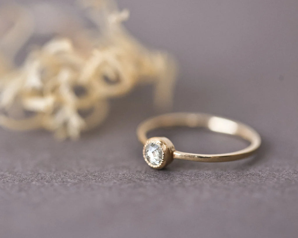 Close-up of yellow-grey rose-cut diamond ring with fine gold band