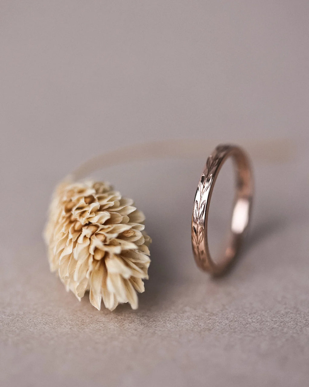 Side profile of handmade olive leaf engraved wedding ring in rose gold