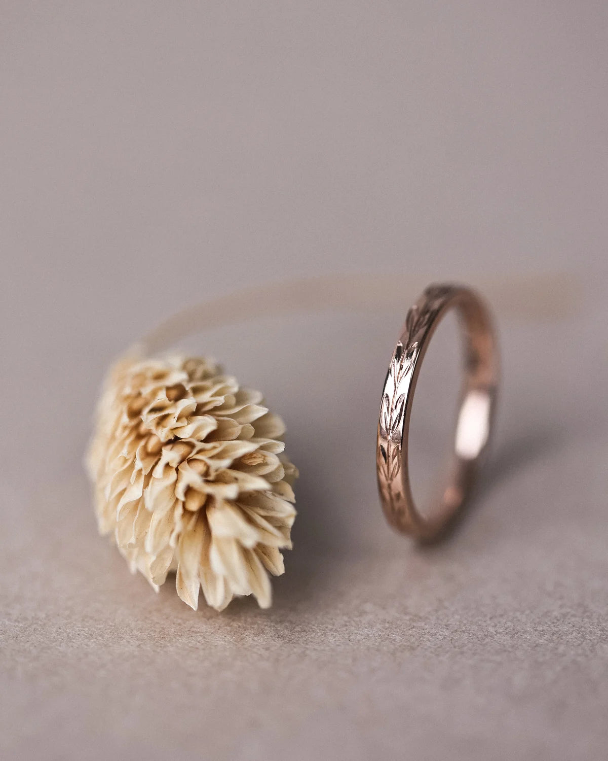 Side profile of handmade olive leaf engraved wedding ring in rose gold