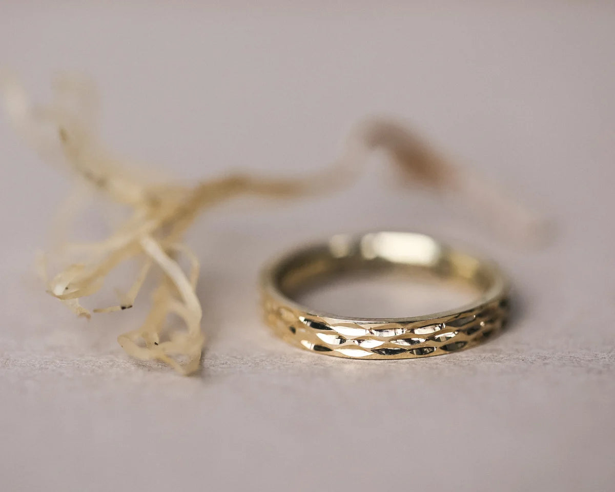 natural light on textured gold wedding ring close up