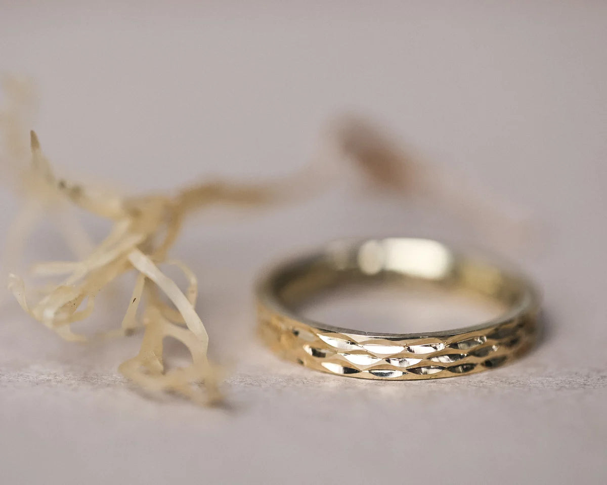 close up ocean engraving on 3mm gold ring fluid texture detail