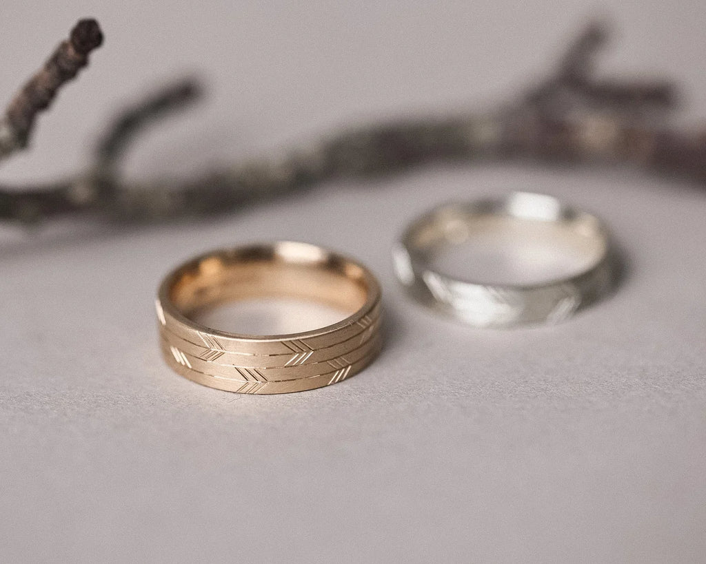 engraved texture gold wedding band arrow design close up