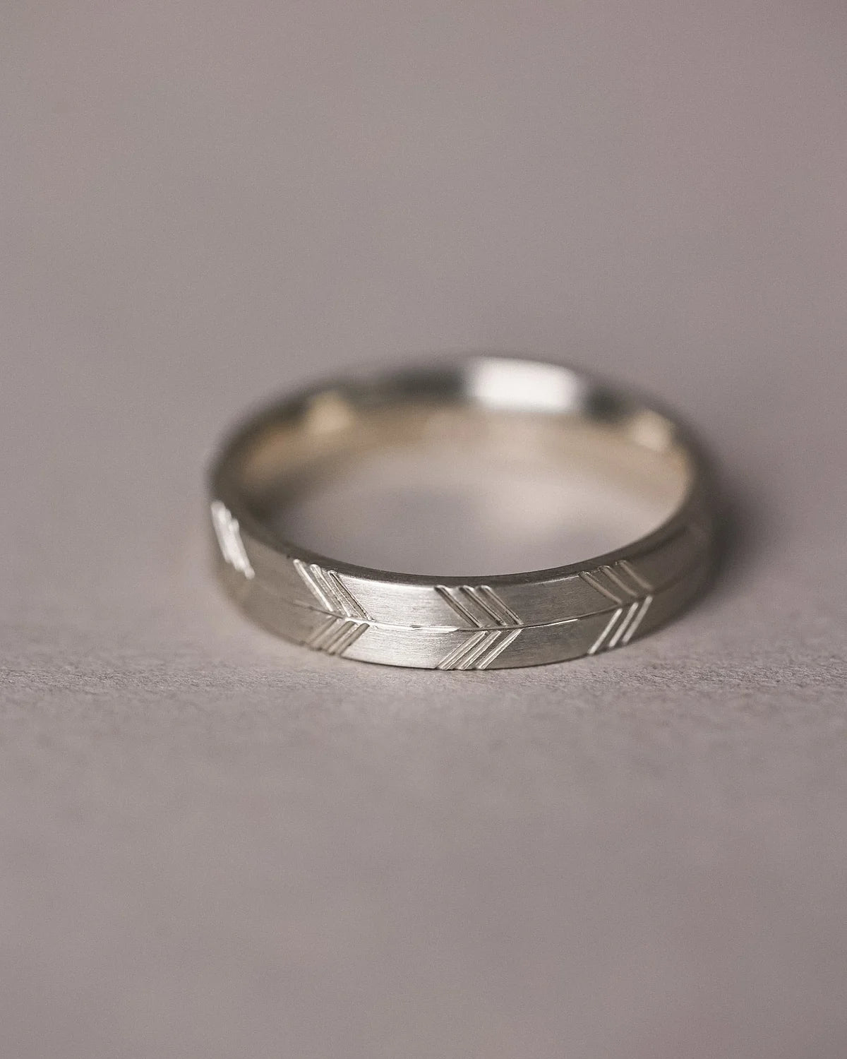 carved arrow design white gold band close view