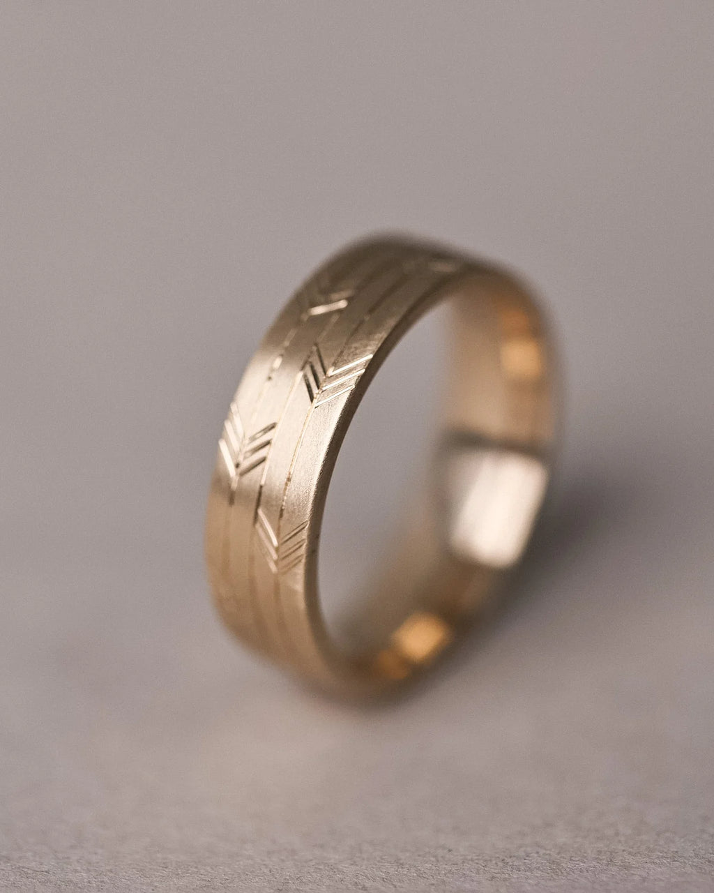 textured arrow motif gold band close view