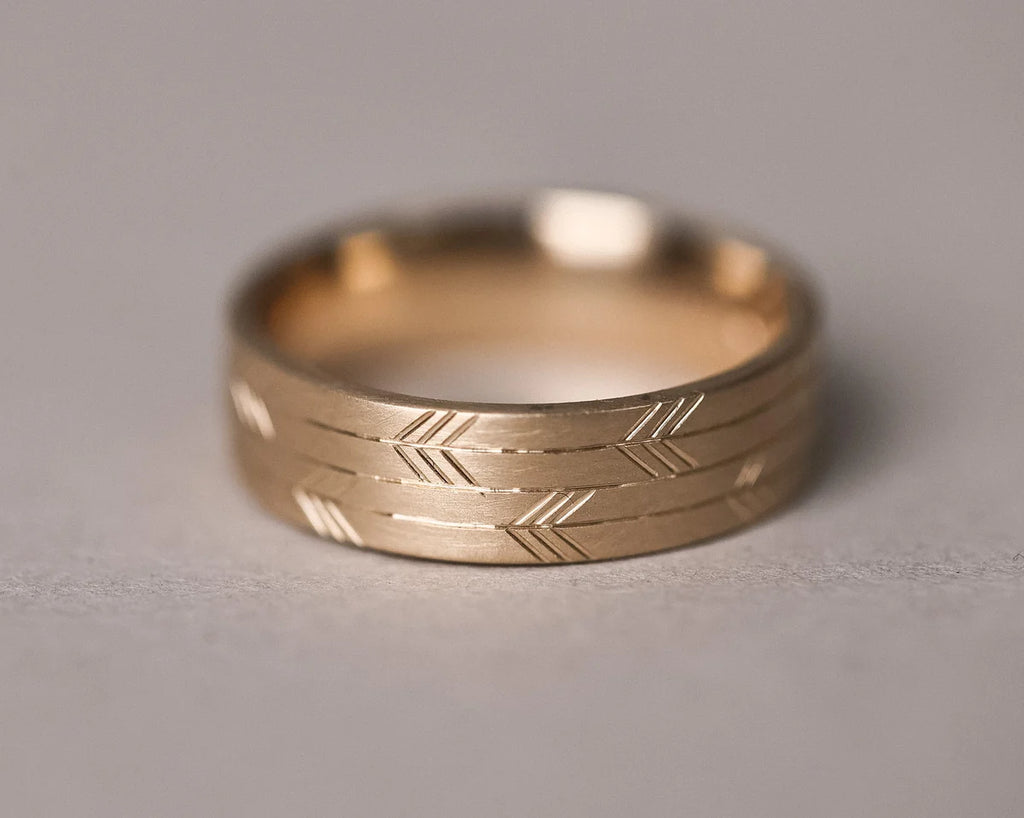 engraved japanese arrow motif gold ring texture detail