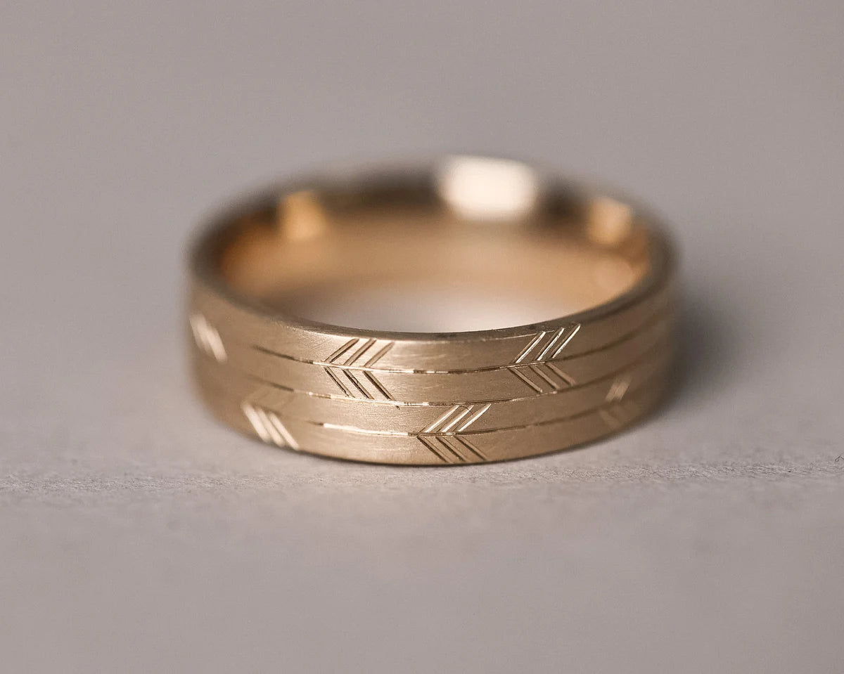 engraved japanese arrow motif gold ring texture detail