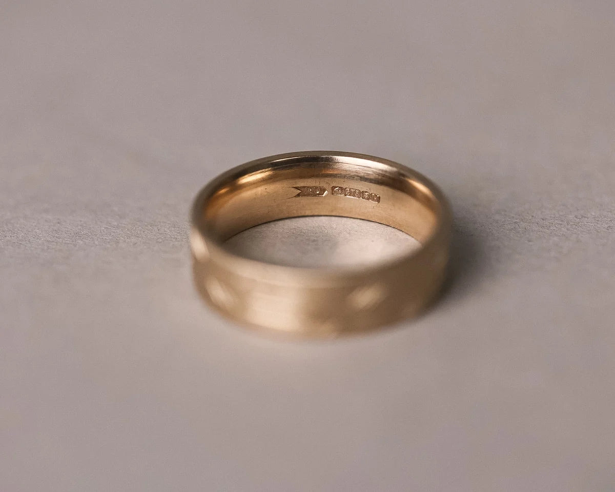 Gold ring with '14k' marking on a gray background