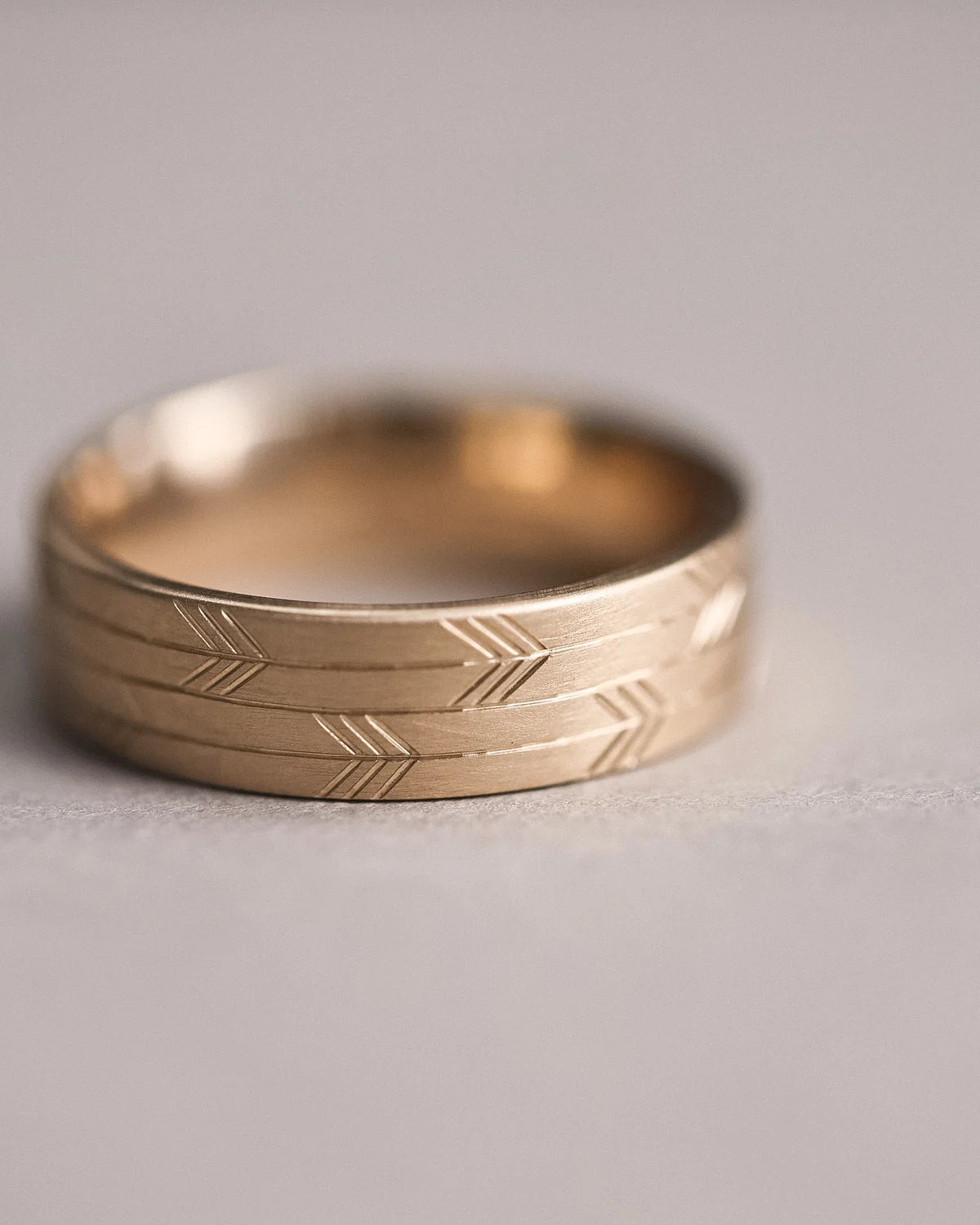 profile view wide gold ring engraved arrow pattern clean edge