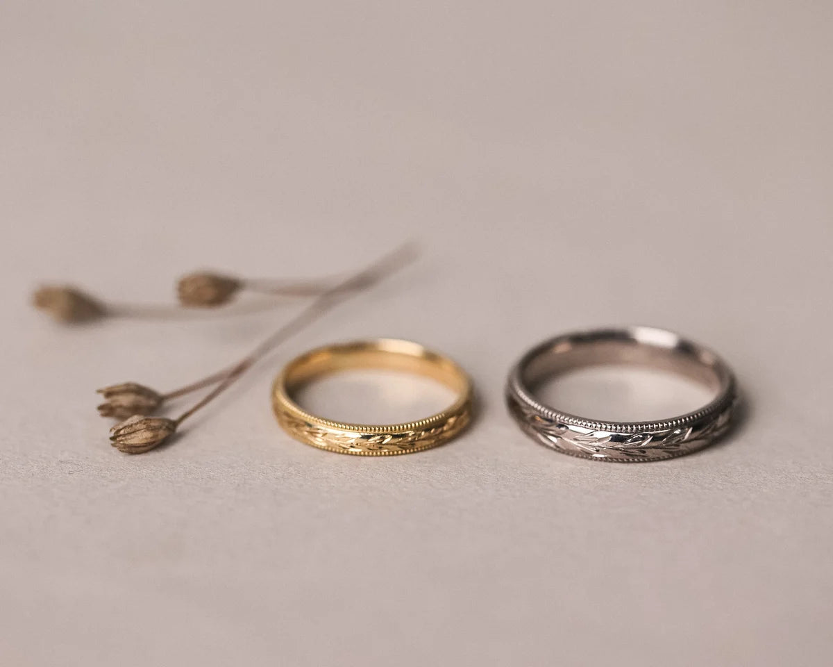 Two gold and silver rings on a neutral background