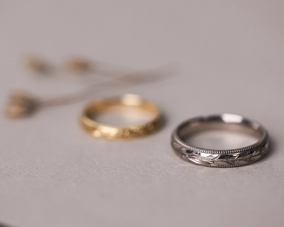 White gold olive leaf and milled edge wedding ring paired with yellow gold band
