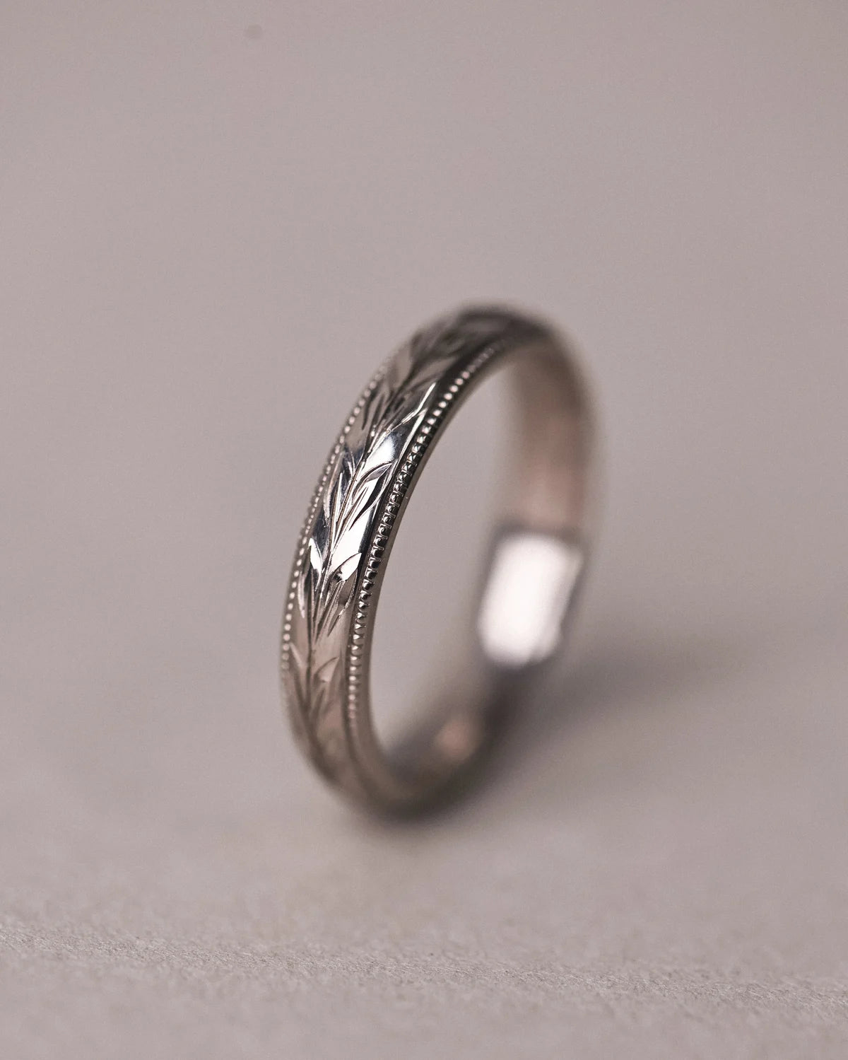 Side view of 4mm white gold ring with hand engraved olive leaf detail