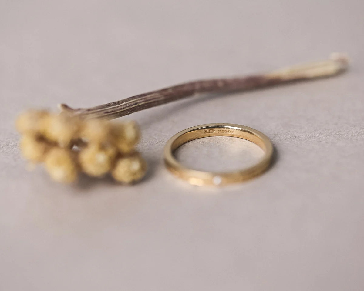 Close-up of handmade yellow gold eternity ring with star set diamond