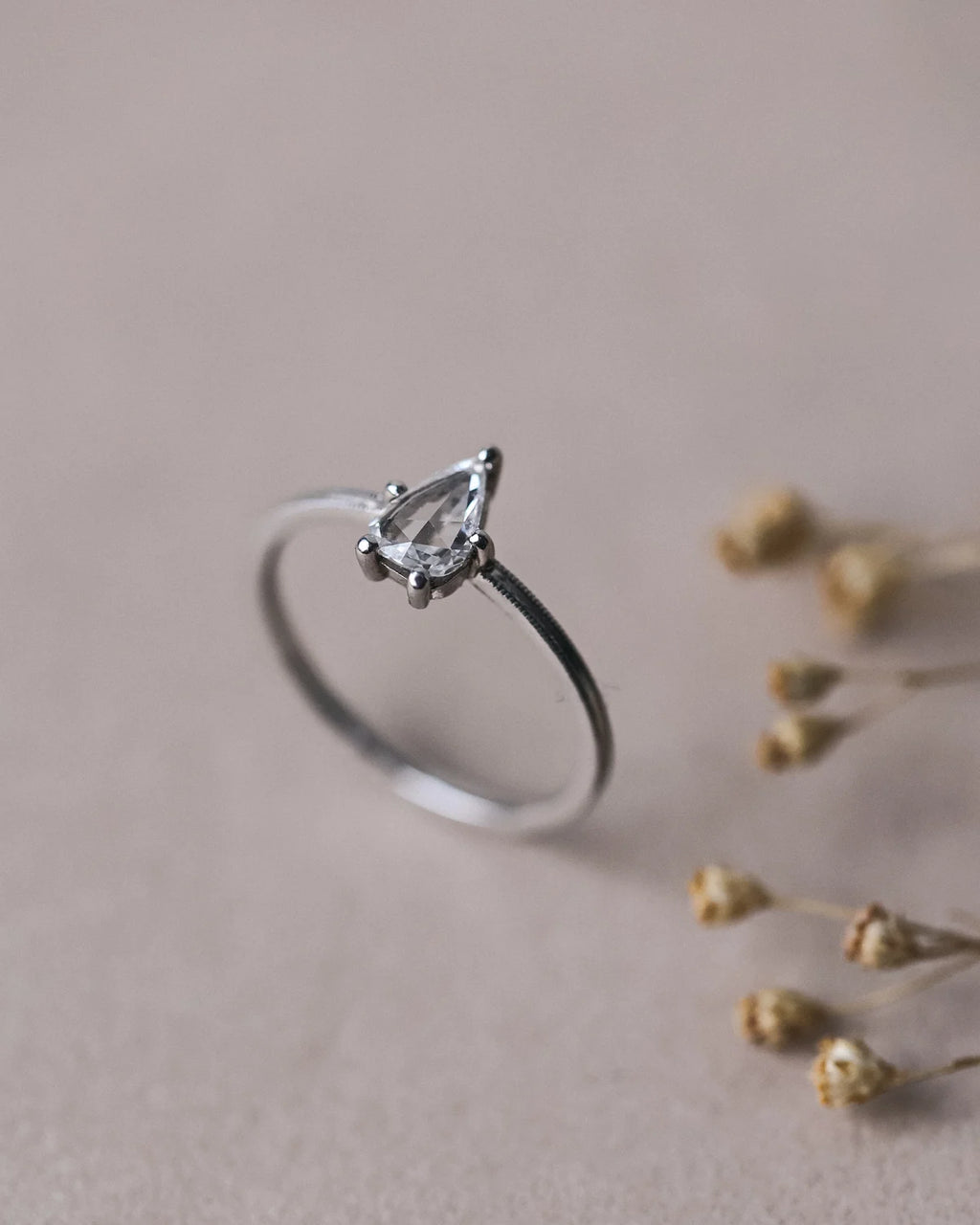 Side view of handmade pear cut diamond ring in platinum
