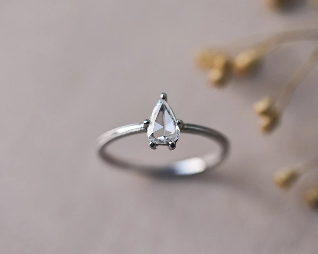 Pear cut diamond ring in platinum styled with dried botanical detail