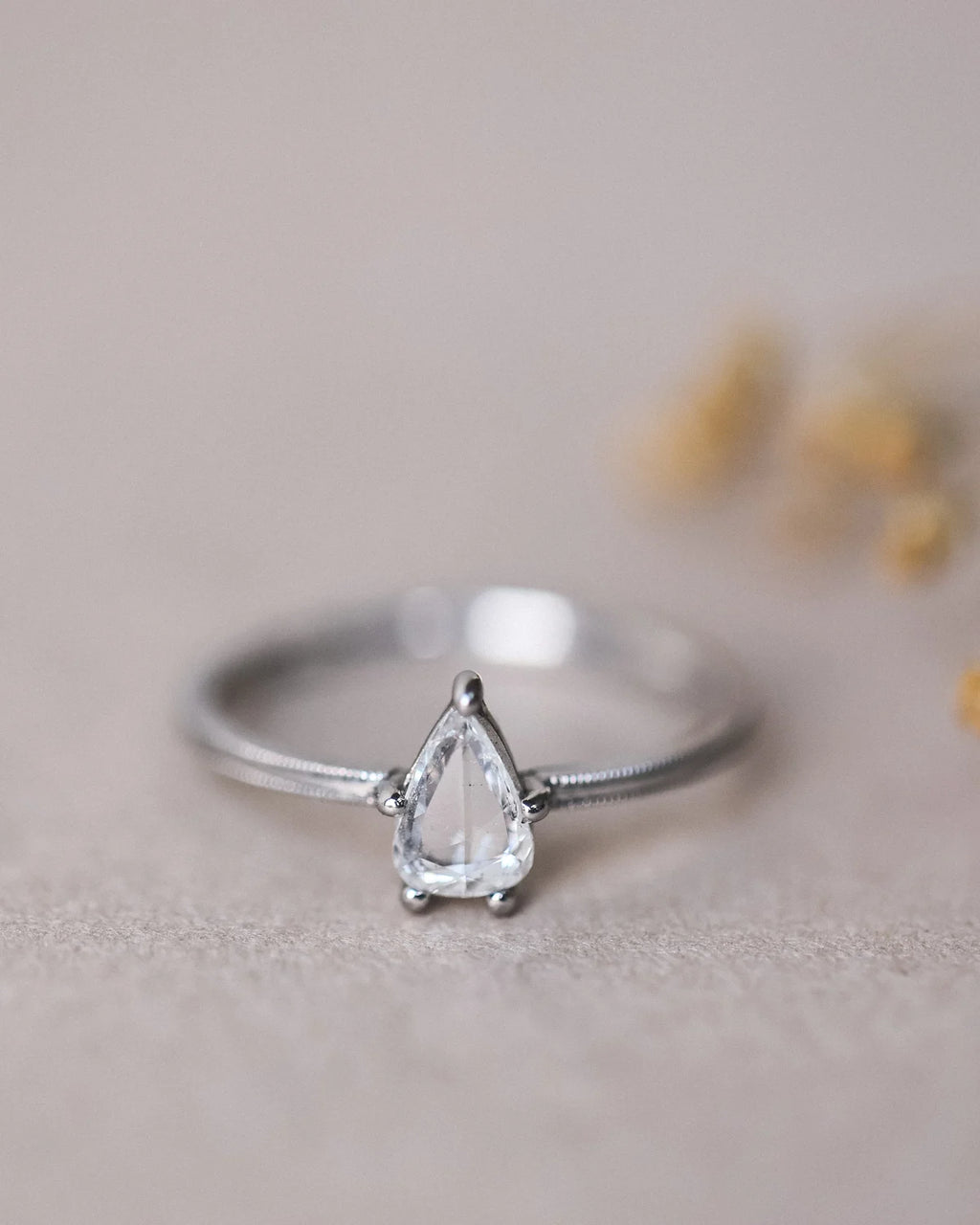 Front view of pear cut diamond ring with delicate platinum band