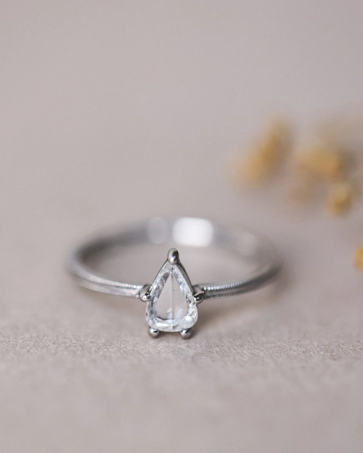 Front view of pear cut diamond ring with delicate platinum band