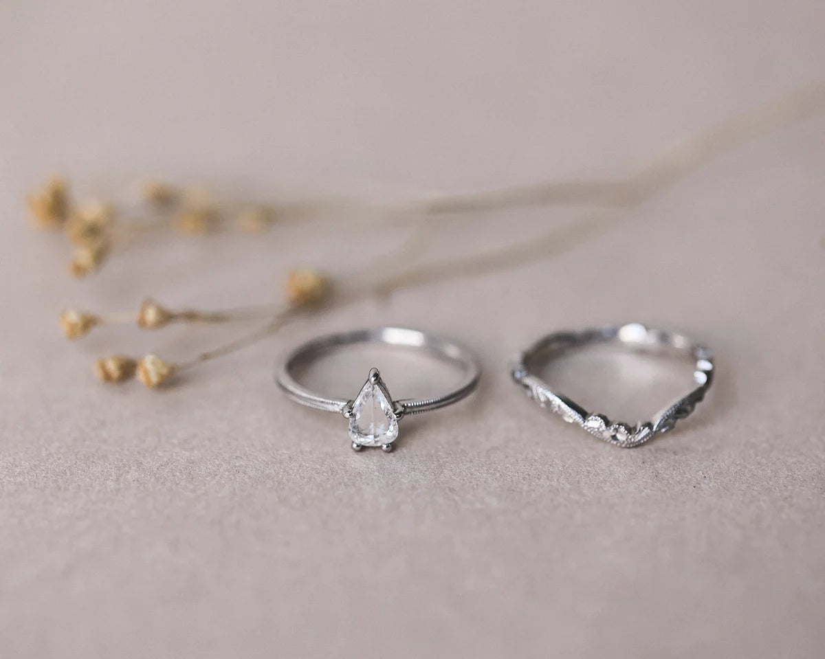 Pear cut diamond ring shown beside matching wishbone band