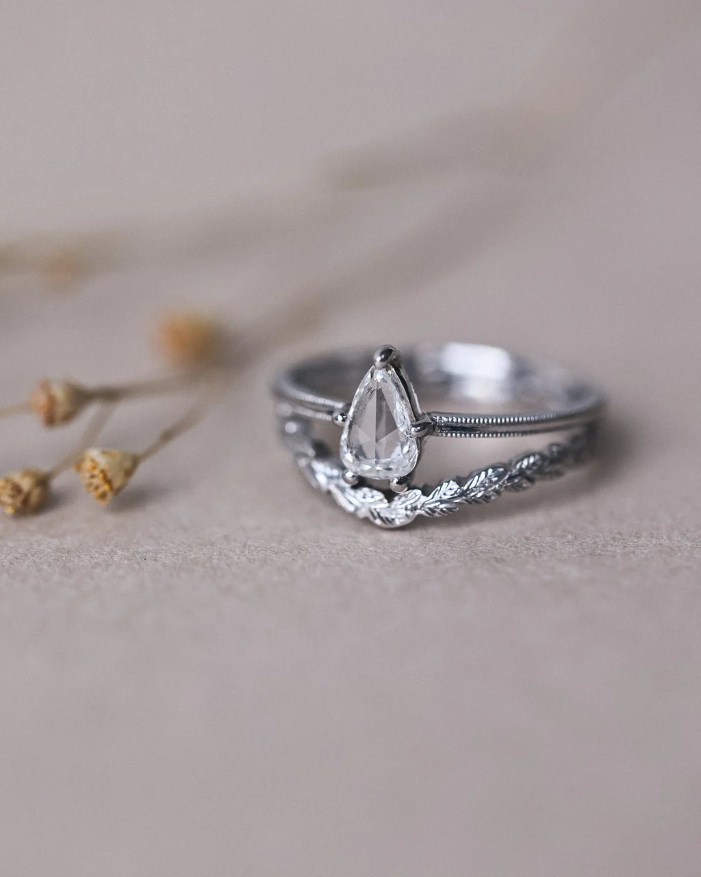 Pear cut diamond engagement ring stacked with wishbone wedding band