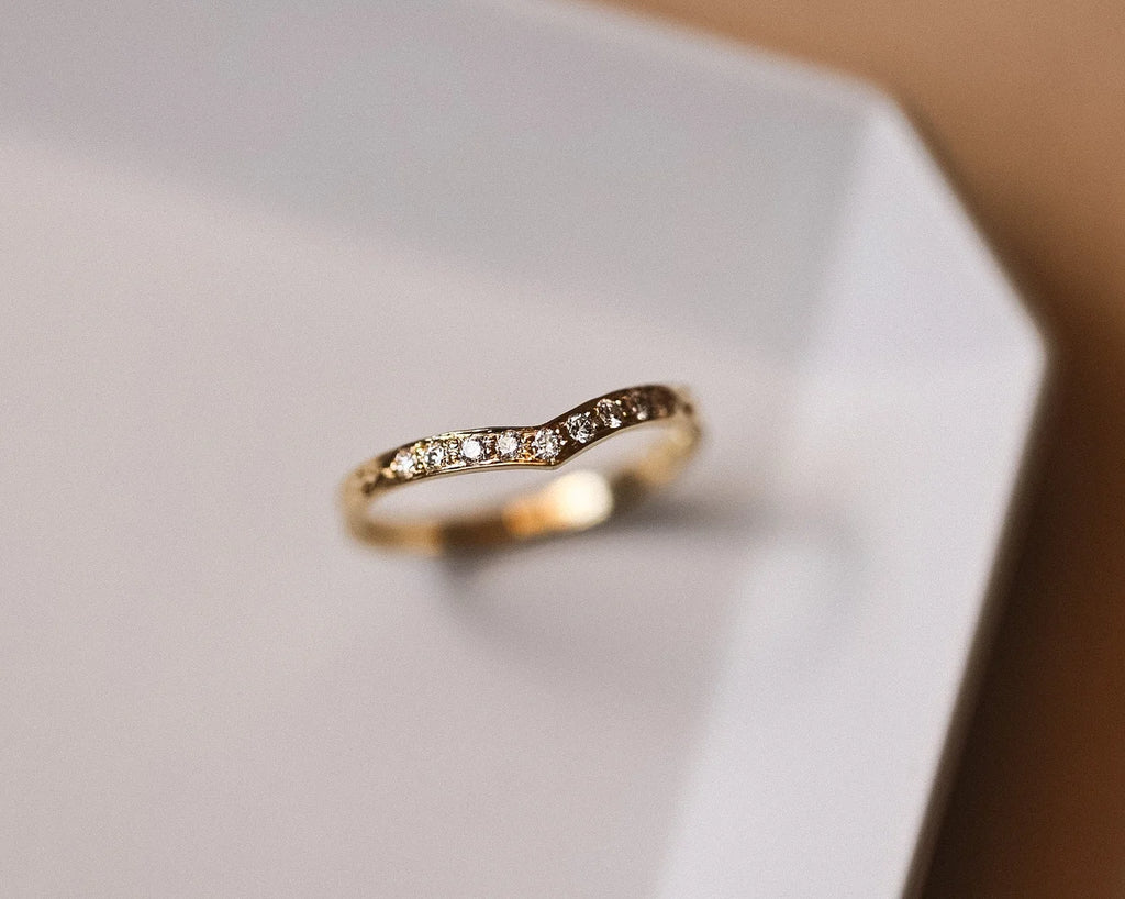 Angled close-up of 18ct yellow gold pavé diamond wishbone ring