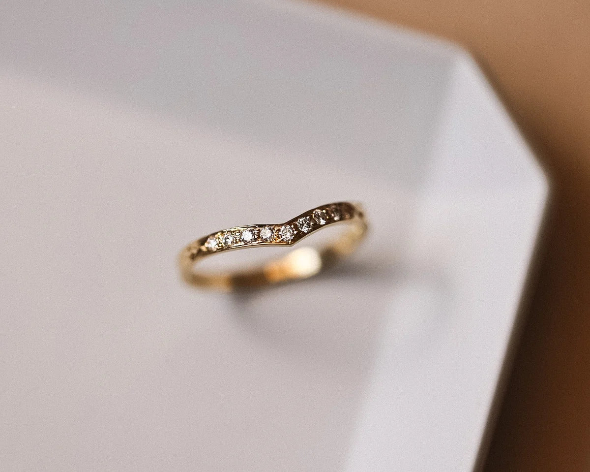 Angled close-up of 18ct yellow gold pavé diamond wishbone ring