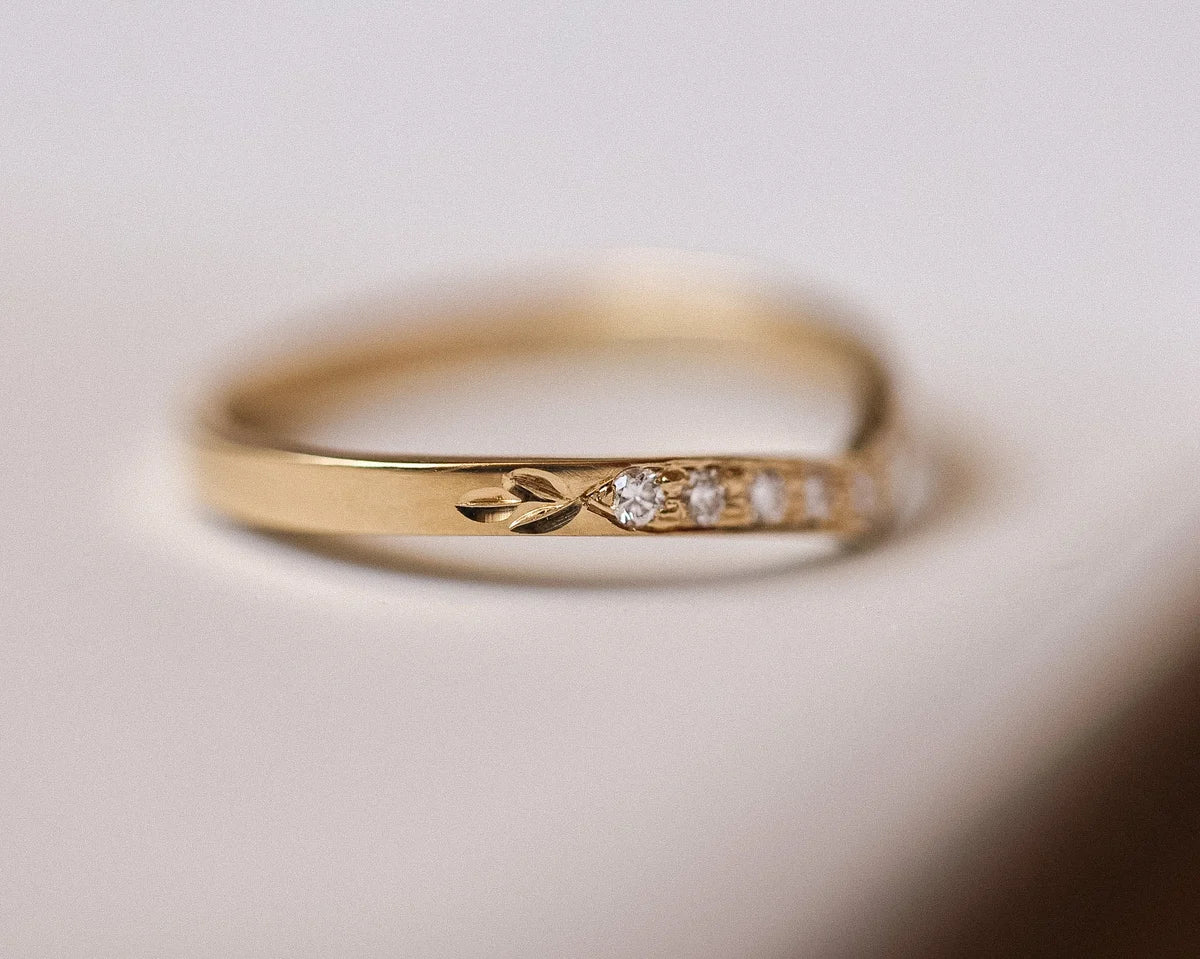 Close-up of pavé set white diamonds and hand engraved leaf detail