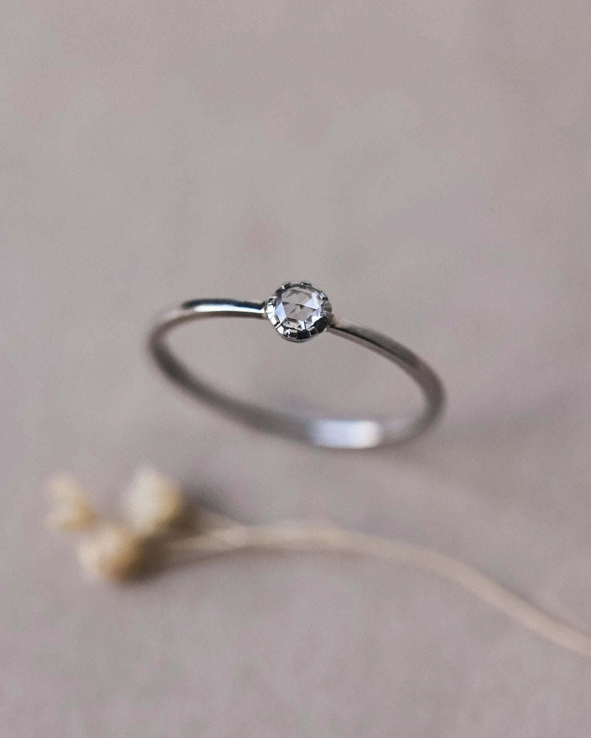 Close-up of platinum rose-cut diamond ring with fine plain band