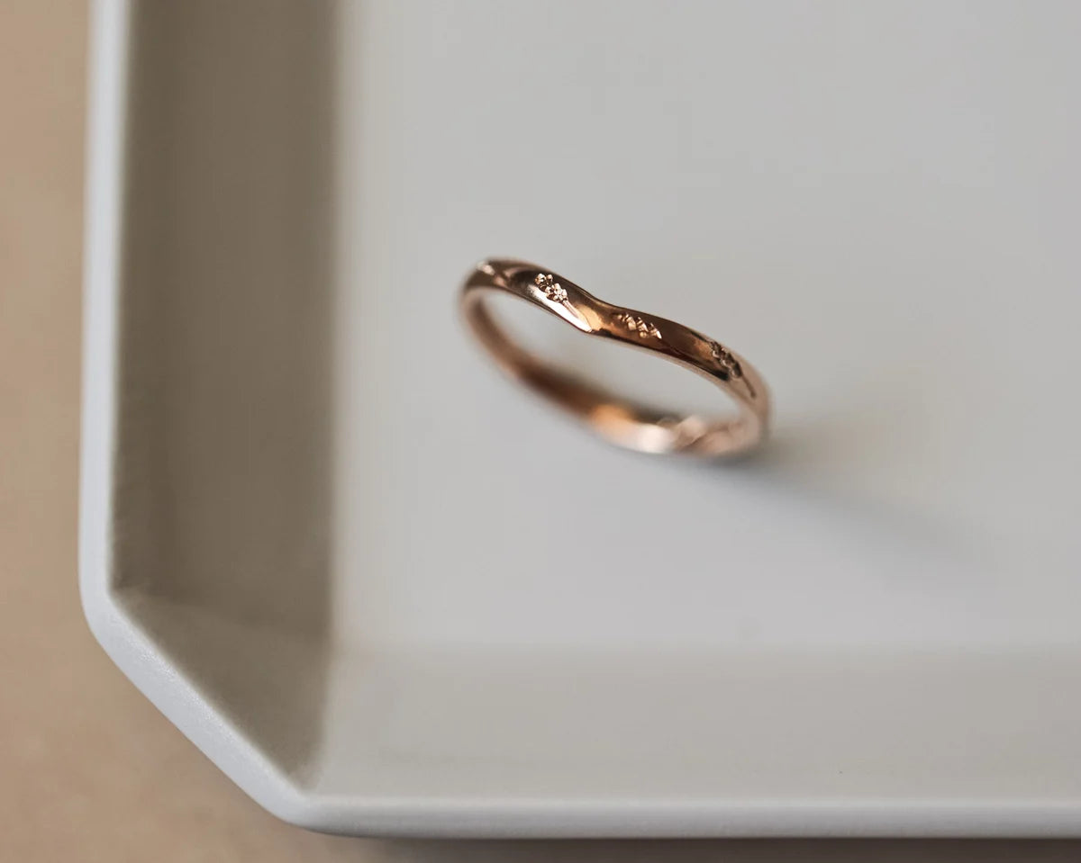 Angled view of handmade rose gold barleycorn wishbone ring