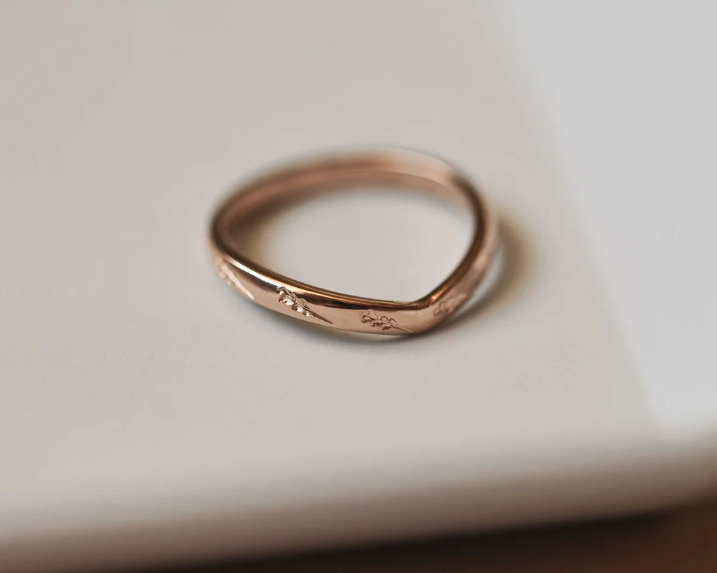 Minimal rose gold barleycorn engraved wishbone ring on ceramic dish