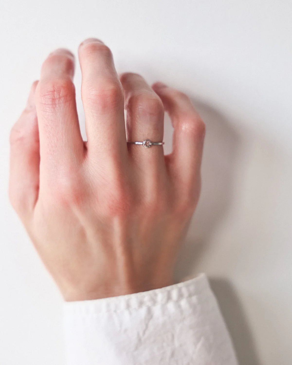 Platinum rose-cut diamond ring worn on hand in natural light
