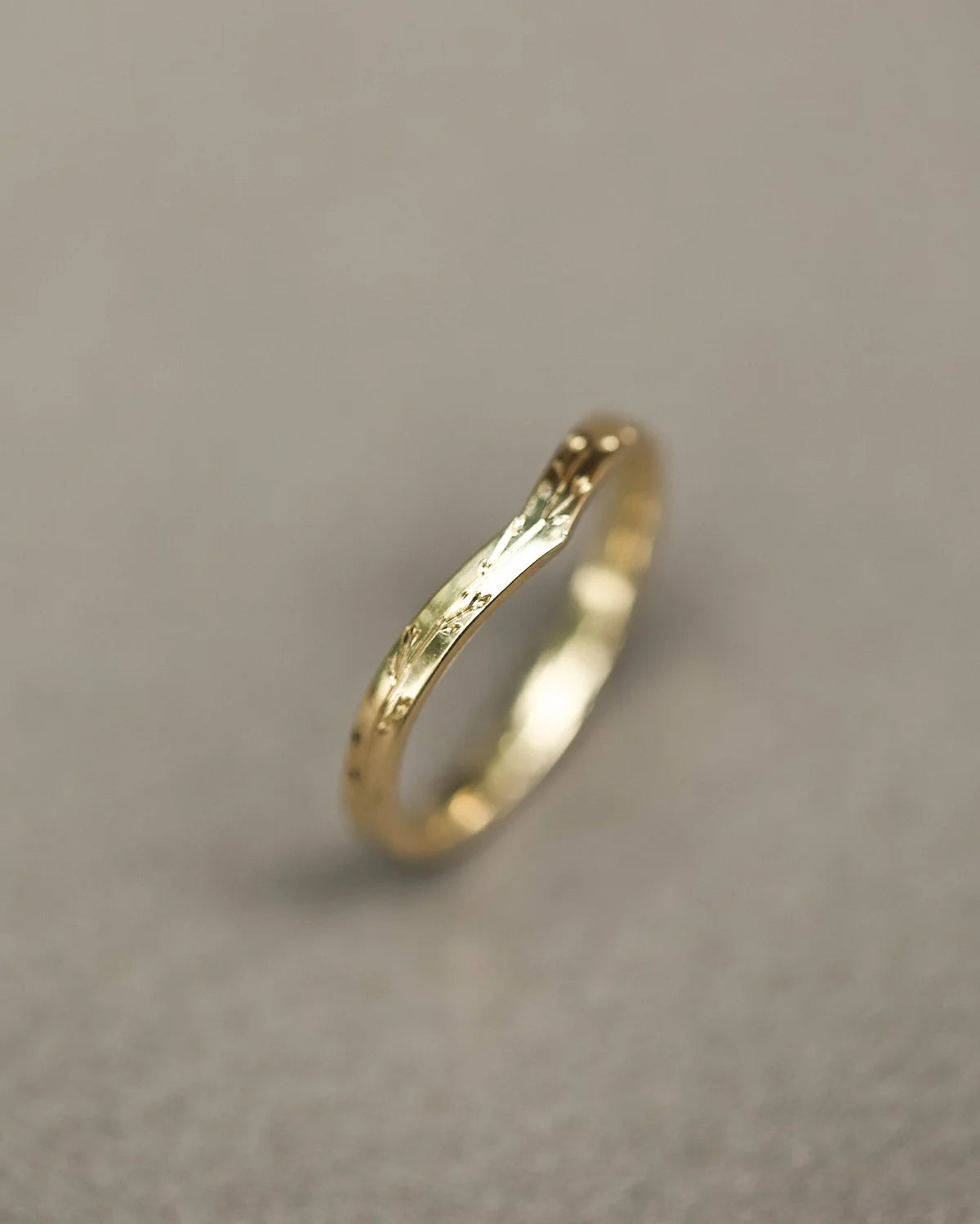 Vertical view of handmade yellow gold pressed flower wishbone ring