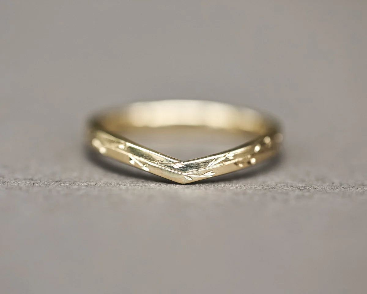 Front view of yellow gold wishbone ring with pressed flower engraving