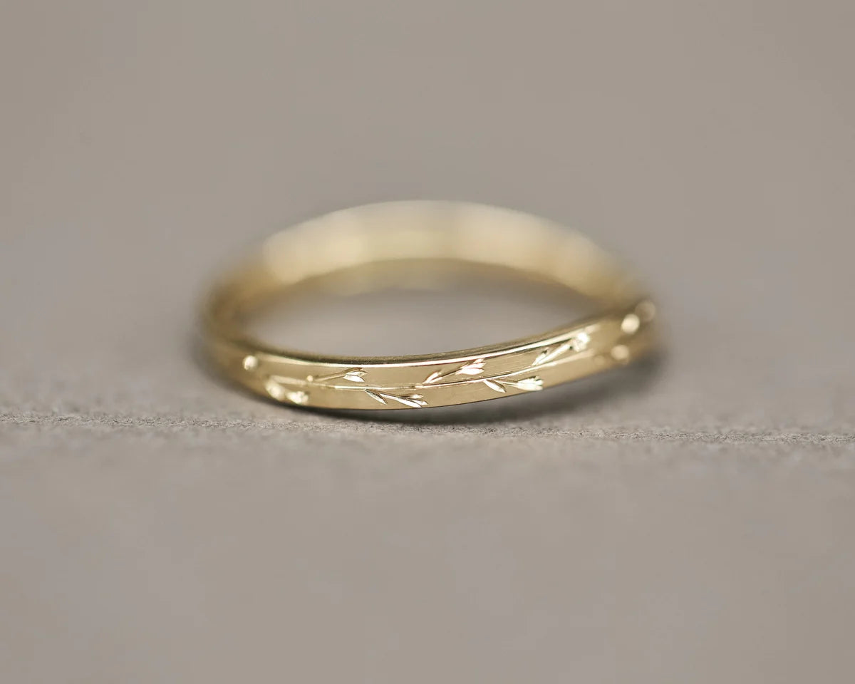 Close-up of 18ct yellow gold pressed flower wishbone wedding ring