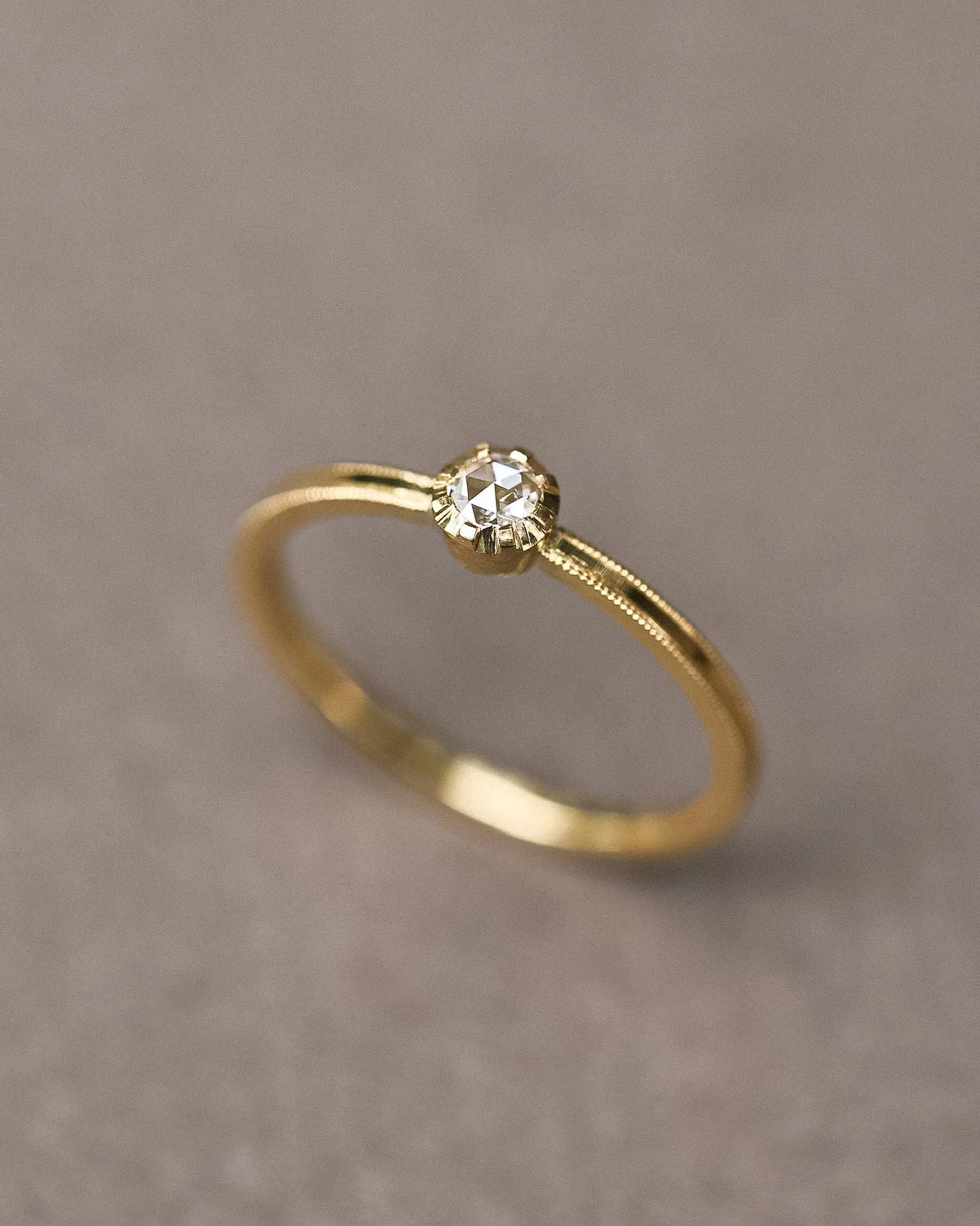 Angled close-up of 18ct yellow gold rose-cut diamond ring