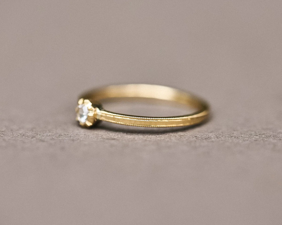 Side view of yellow gold rose-cut diamond ring with fine milled edge