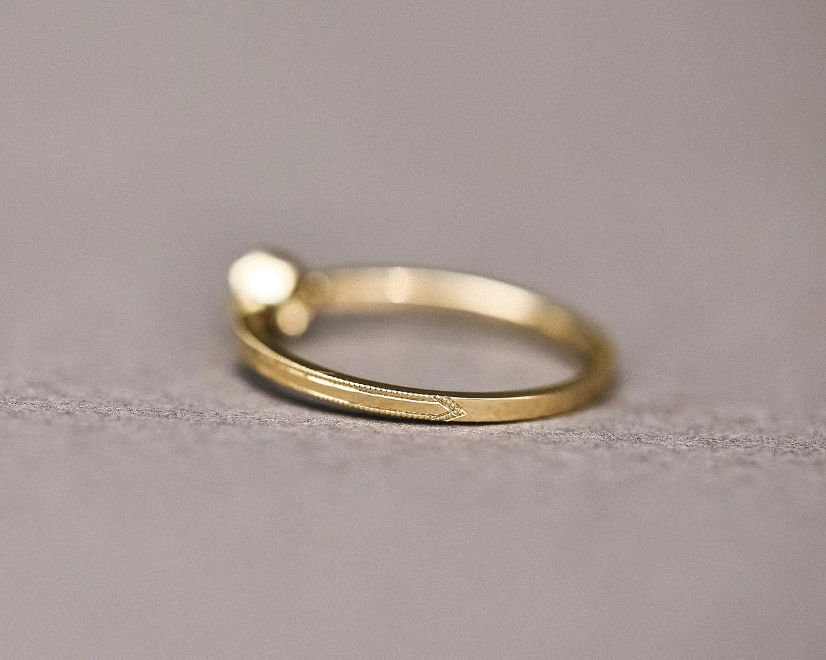 Back view of handmade yellow gold ring with milled edge detail