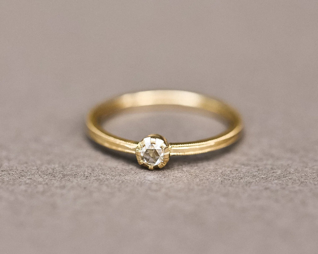 Close-up of 3mm rose-cut diamond ring with handmade yellow gold band