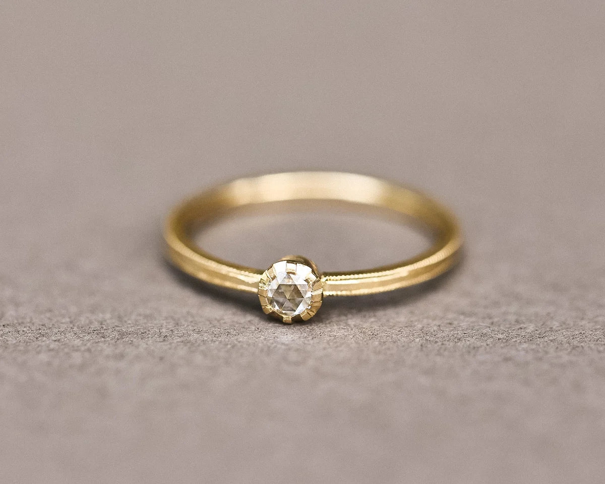 Close-up of 3mm rose-cut diamond ring with handmade yellow gold band