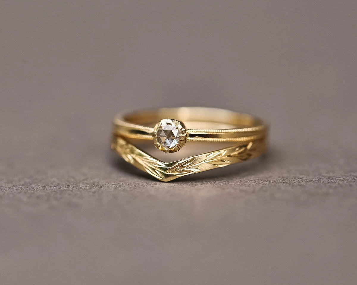 Rose-cut diamond ring paired with engraved wishbone wedding band