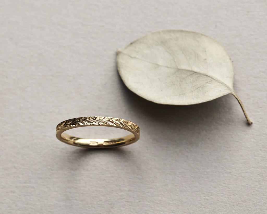 delicate laurel pattern engraved gold band close view