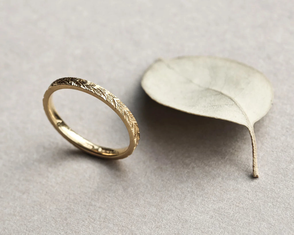 Side profile of laurel leaf engraved flat court ring in yellow gold