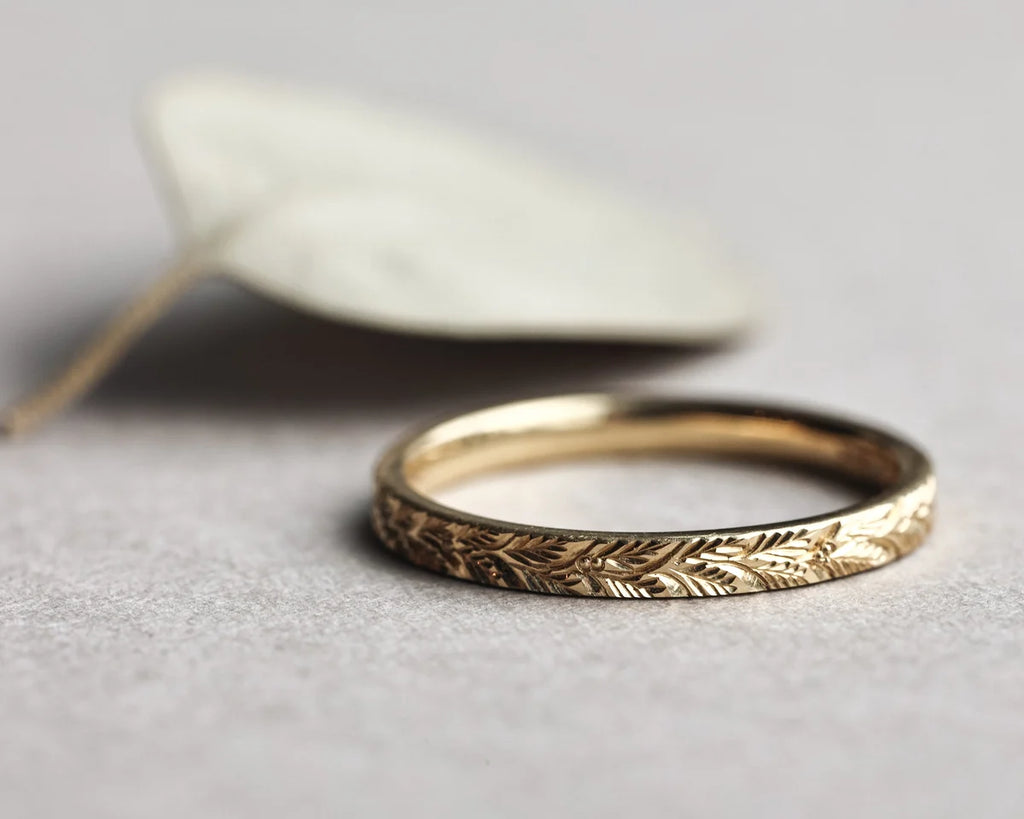 18ct yellow gold laurel leaf wedding ring styled with pale leaf